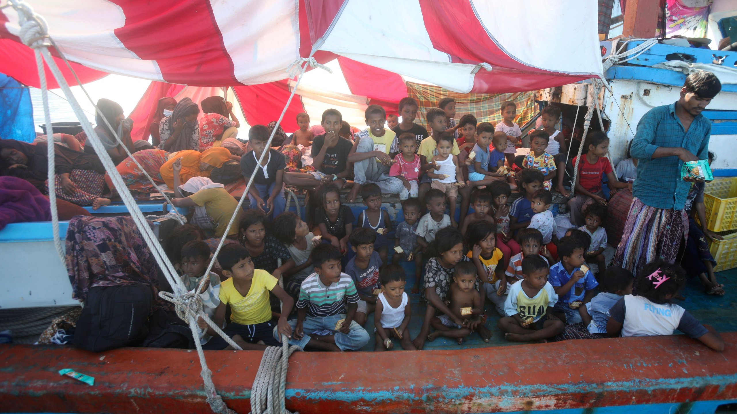 Rohingya children wait for food supply delivered by local fishermen on their boat anchored in the waters near the coast of Labuhan Haji, Aceh province, Indonesia, Tuesday, Oct. 22, 2024. (AP Photo/Binsar Bakkara)