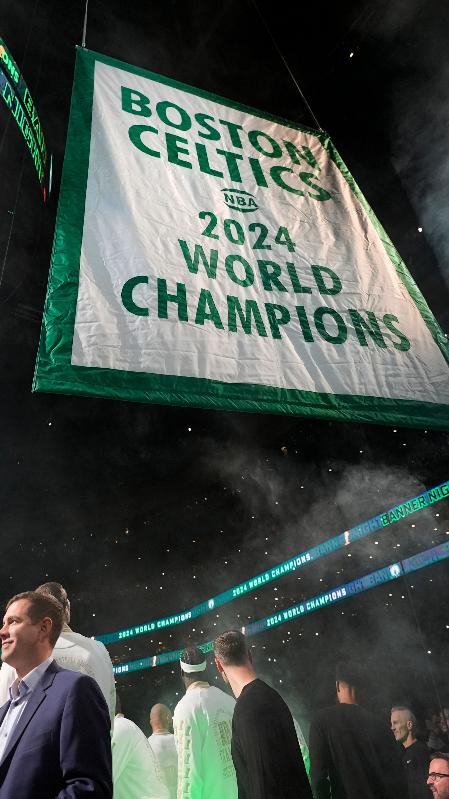 Boston Celtics general manager Brad Stevens, left, looks on as the 2024 World Championship banner is raised prior to an NBA basketball game against the New York Knicks, Tuesday, Oct. 22, 2024, in Boston. (AP Photo/Charles Krupa)