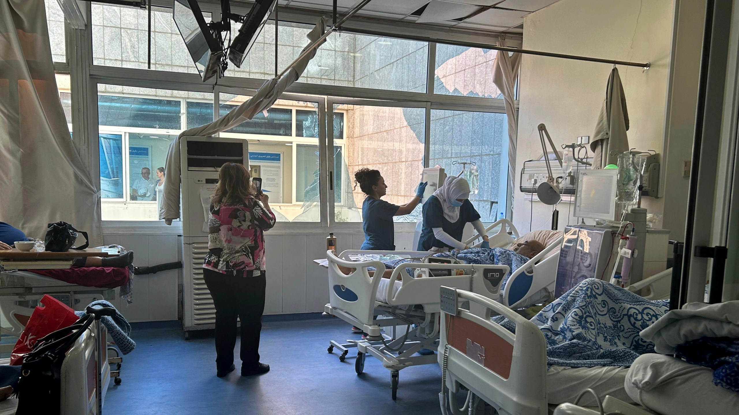 Patients receive treatment at the dialysis unit near broken window at the Rafik Hariri University Hospital, following an overnight Israeli airstrike near the medical facility in southern Beirut, Lebanon, Tuesday, Oct. 22, 2024. (AP Photo/Sarah el-Deeb)