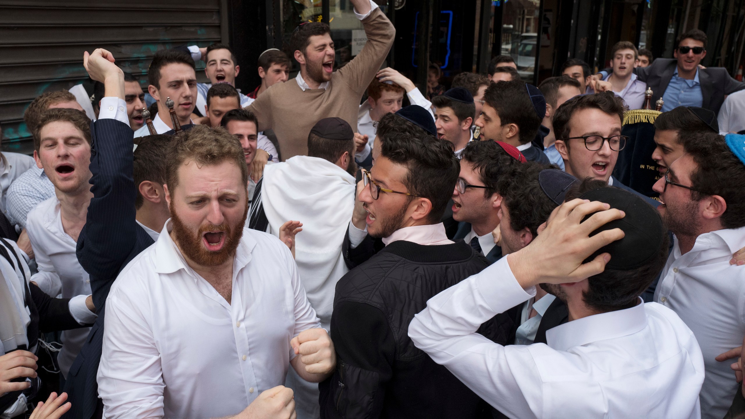 FILE - Jewish men celebrate Simchat Torah on a New York street, Friday, Oct. 13, 2017. The holiday marks the conclusion of the annual cycle of public Torah readings. (AP Photo/Mark Lennihan, File)