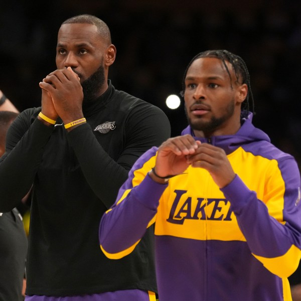 Los Angeles Lakers forward LeBron James, left, and guard Bronny James warm up before an NBA basketball game against the Minnesota Timberwolves, Tuesday, Oct. 22, 2024, in Los Angeles. (AP Photo/Eric Thayer)