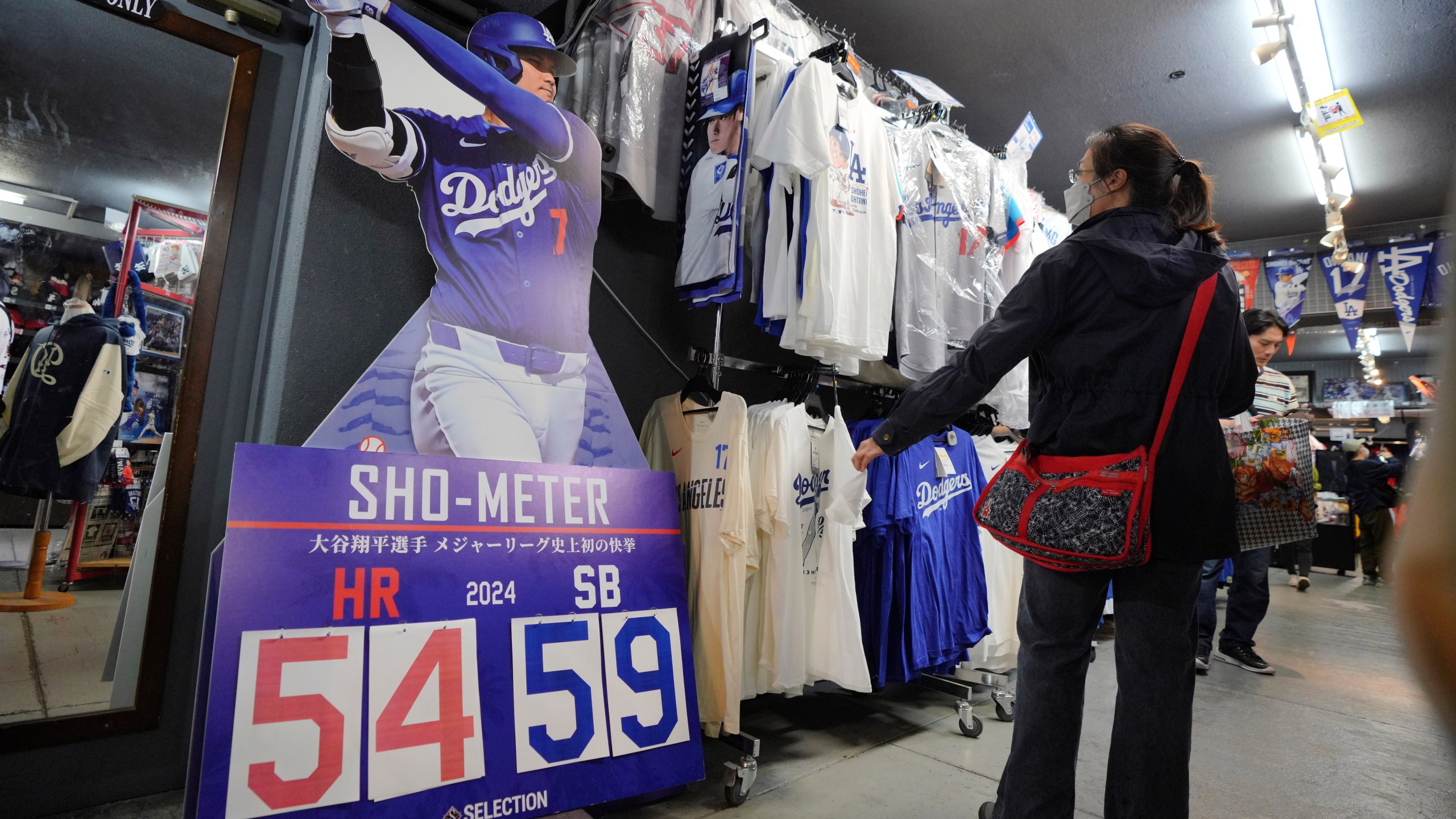 Customers shop around for goods related to Shohei Ohtani of the Los Angeles Dodgers at a sporting goods store, "SELECTION," in Shinjuku district Wednesday, Oct. 23, 2024 in Tokyo. (AP Photo/Eugene Hoshiko)