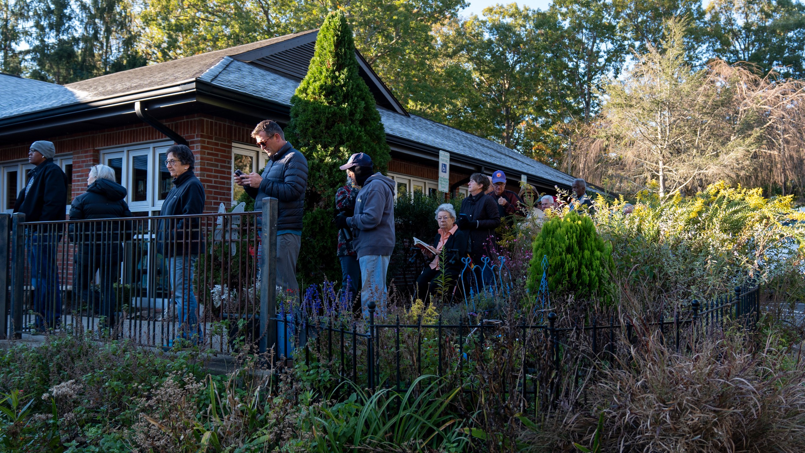 People wait in line at the polling place at Skyland/South Buncombe Library in Asheville, N.C. during the first day of early in-person voting, on Oct. 17, 2024. (AP Photo/Stephanie Scarbrough)