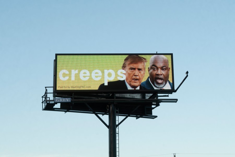 A billboard linking former President Donald Trump and Republican gubernatorial nominee Mark Robinson looms U.S. 1 in Youngsville, N.C., on Monday, Oct. 14, 2024. Trump has boasted that his U.S. Supreme Court nominees overturned the nationwide right to abortion, and Robinson's controversial statements on abortion have been a focus of Democrats in the state. (AP Photo/Allen G. Breed)