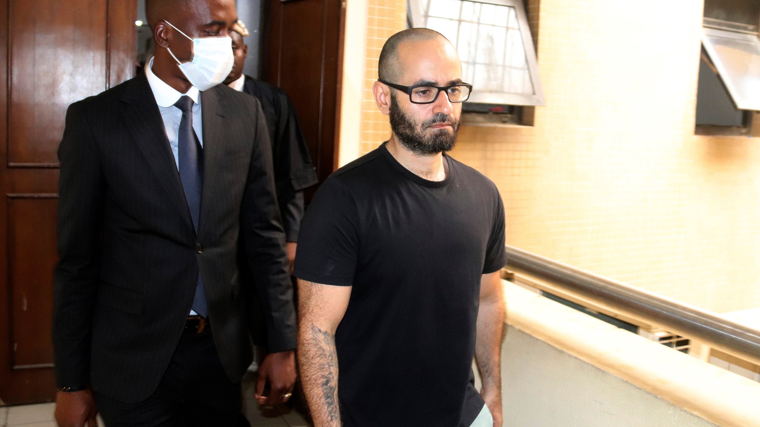 FILE - Tigran Gambaryan, an American citizen and Binance's head of financial crime compliance, right, is escorted as he leaves a court hearing at the federal High Courts, in Abuja, Nigeria, April 4, 2024. (AP Photo/Olamikan Gbemiga, File)