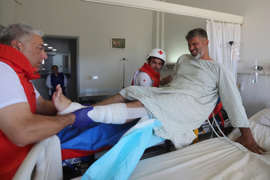 An injured cameraman is moved by the Lebanese Red Cross to a hospital, at the site where an Israeli airstrike hit a compound housing journalists, killing three media staffers from two different news agencies according to Lebanon's state-run National News Agency, in Hasbaya village, southeast Lebanon, Friday, Oct. 25, 2024. (AP Photo/Mohammed Zaatari)