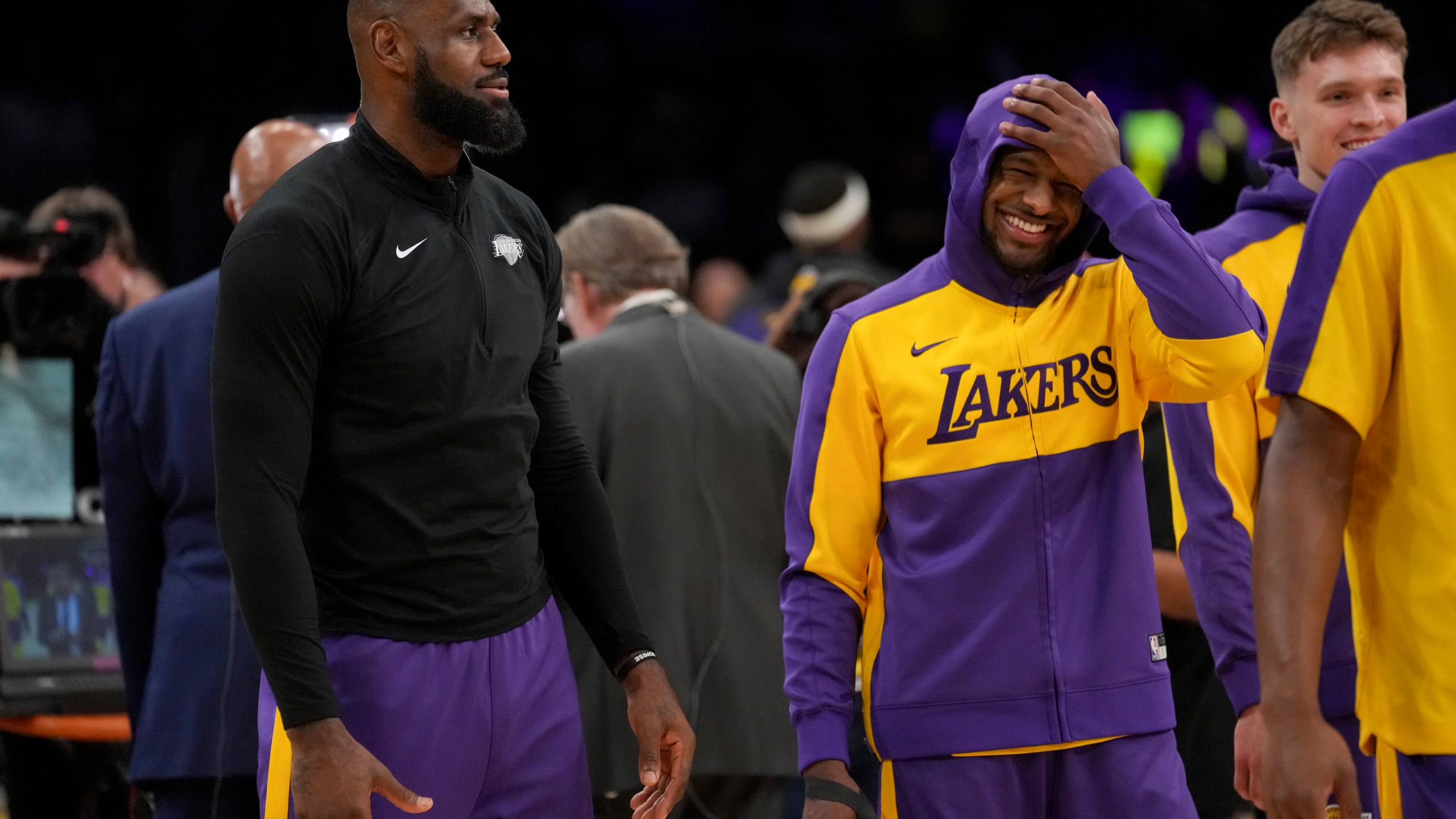 Los Angeles Lakers forward LeBron James, left, and his son, guard Bronny James warm up prior to an NBA basketball game against the Phoenix Suns in Los Angeles, Friday, Oct. 25, 2024. (AP Photo/Eric Thayer)