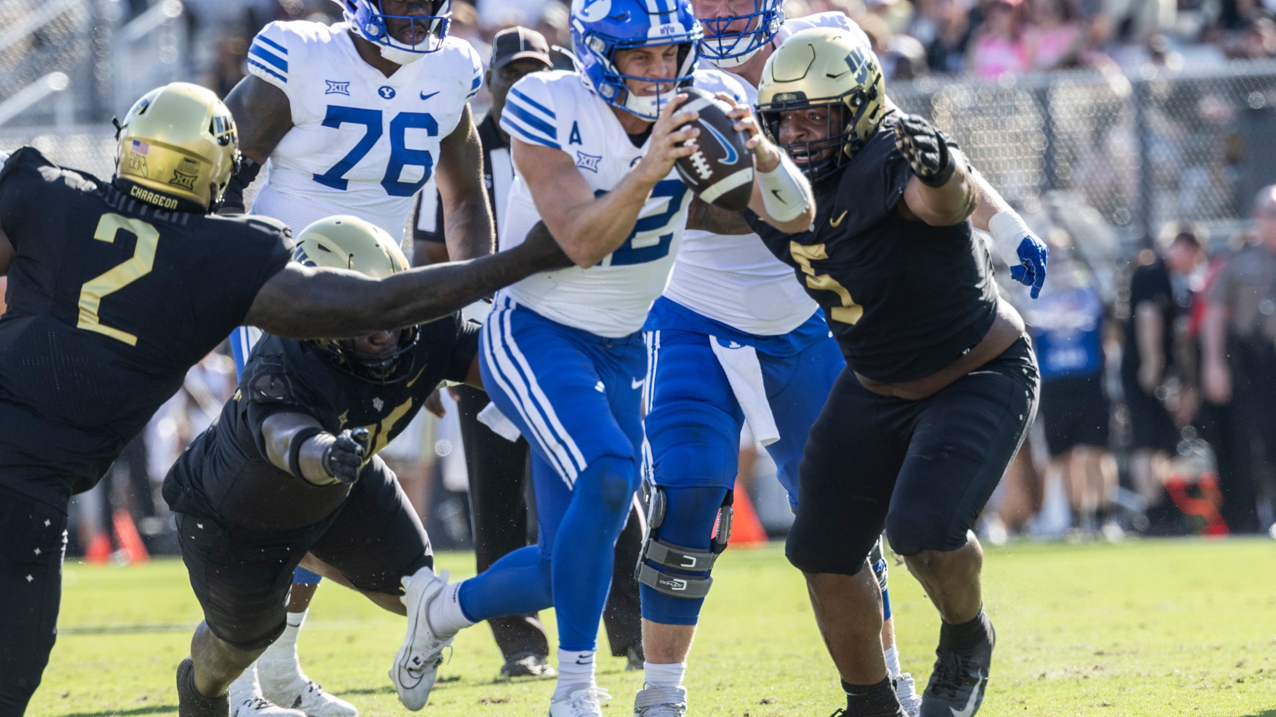 BYU quarterback Jake Retzlaff, Center, is sacked by Central Florida's defense during the first half of an NCAA college football game, Saturday, Oct. 26, 2024, in Orlando, Fla. (AP Photo/Kevin Kolczynski)