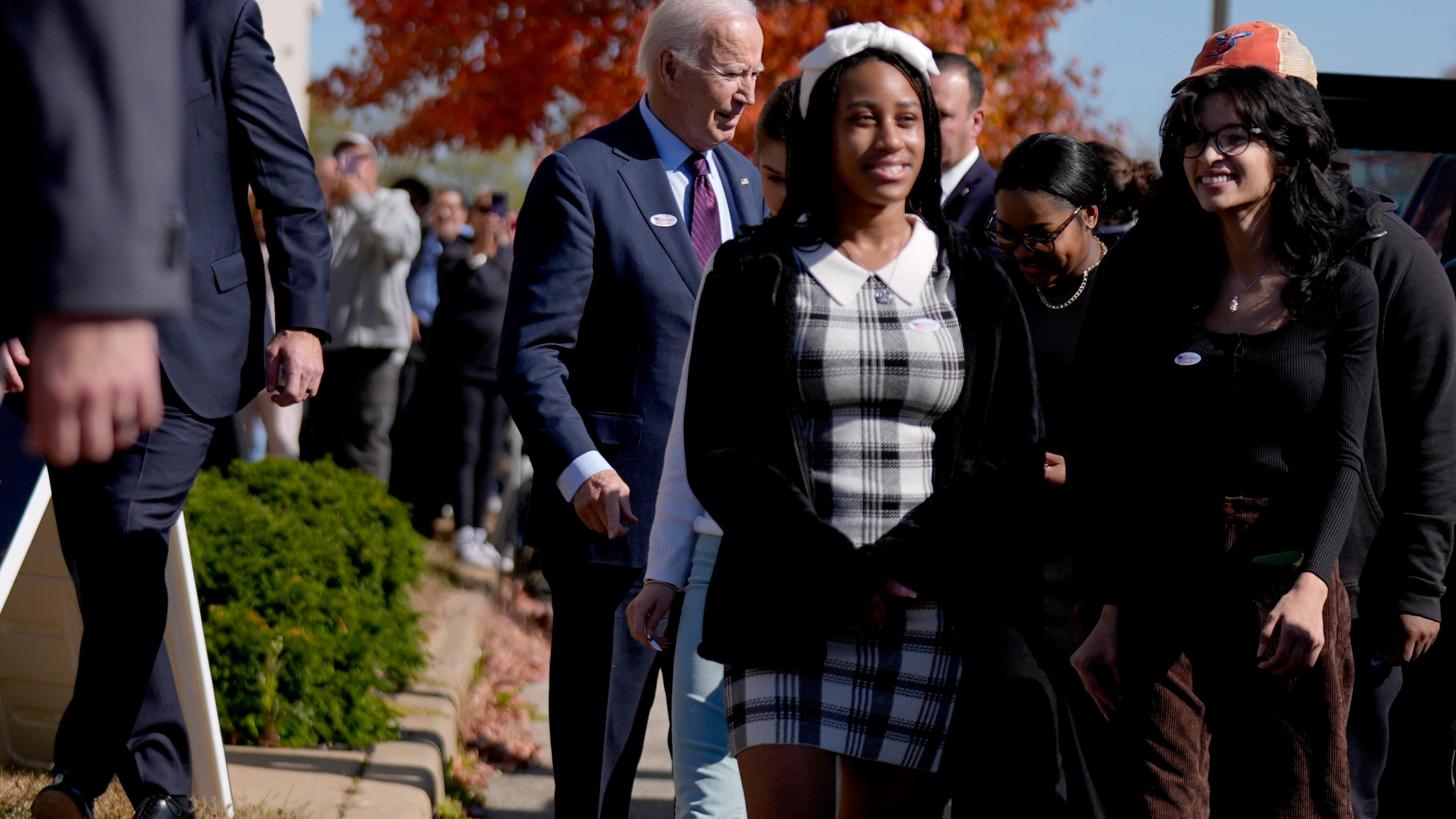 President Joe Biden, left, departs a polling station alongside first-time voters after casting his early-voting ballot for the 2024 general elections, Monday, Oct. 28, 2024, in New Castle, Del. (AP Photo/Manuel Balce Ceneta)