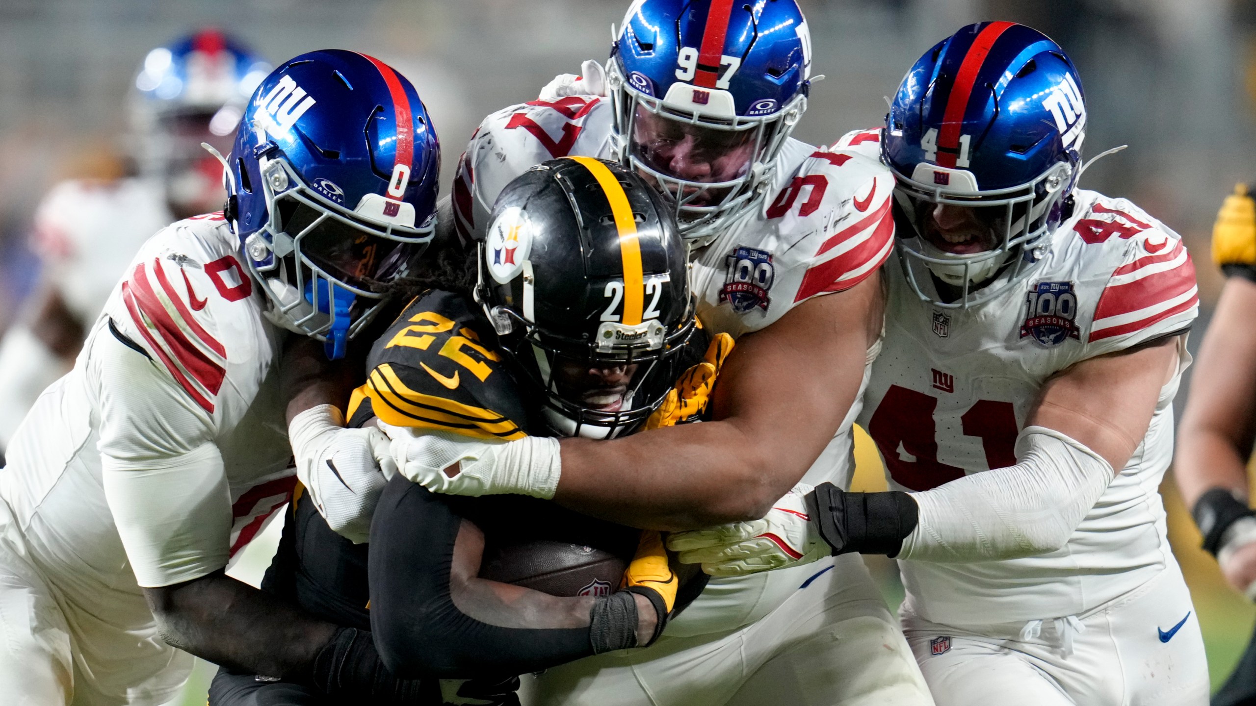 Pittsburgh Steelers running back Najee Harris (22) is tackled by New York Giants linebacker Brian Burns (0) defensive tackle Dexter Lawrence II (97) and linebacker Micah McFadden (41) during the second half of an NFL football game Monday, Oct. 28, 2024, in Pittsburgh. (AP Photo/Gene J. Puskar)