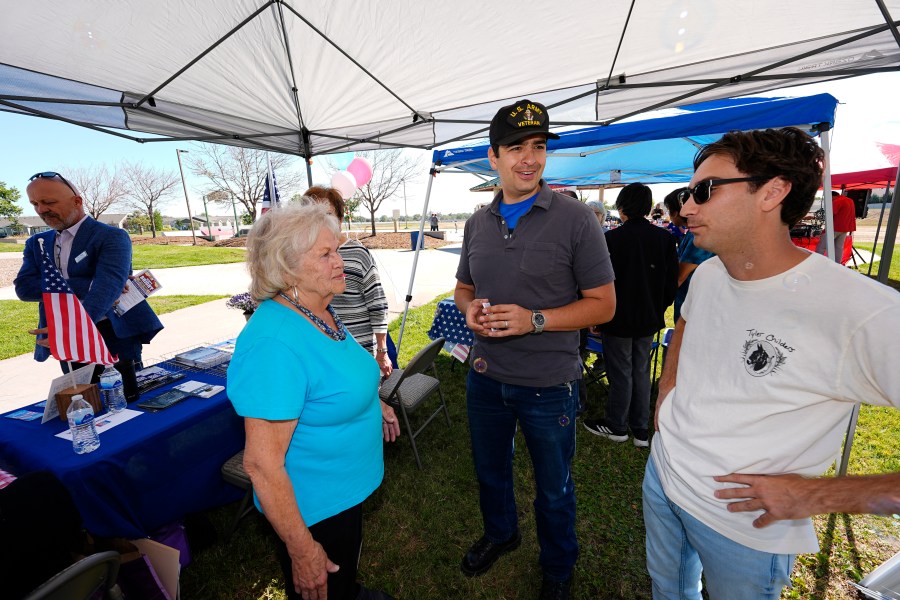 Gabe Evans, Republican candidate for the U.S. House District 8 in Colorado, talks to Annette Hayes during a campaign stop Saturday, Sept. 28, 2024, in Evans, Colo. (AP Photo/David Zalubowski)