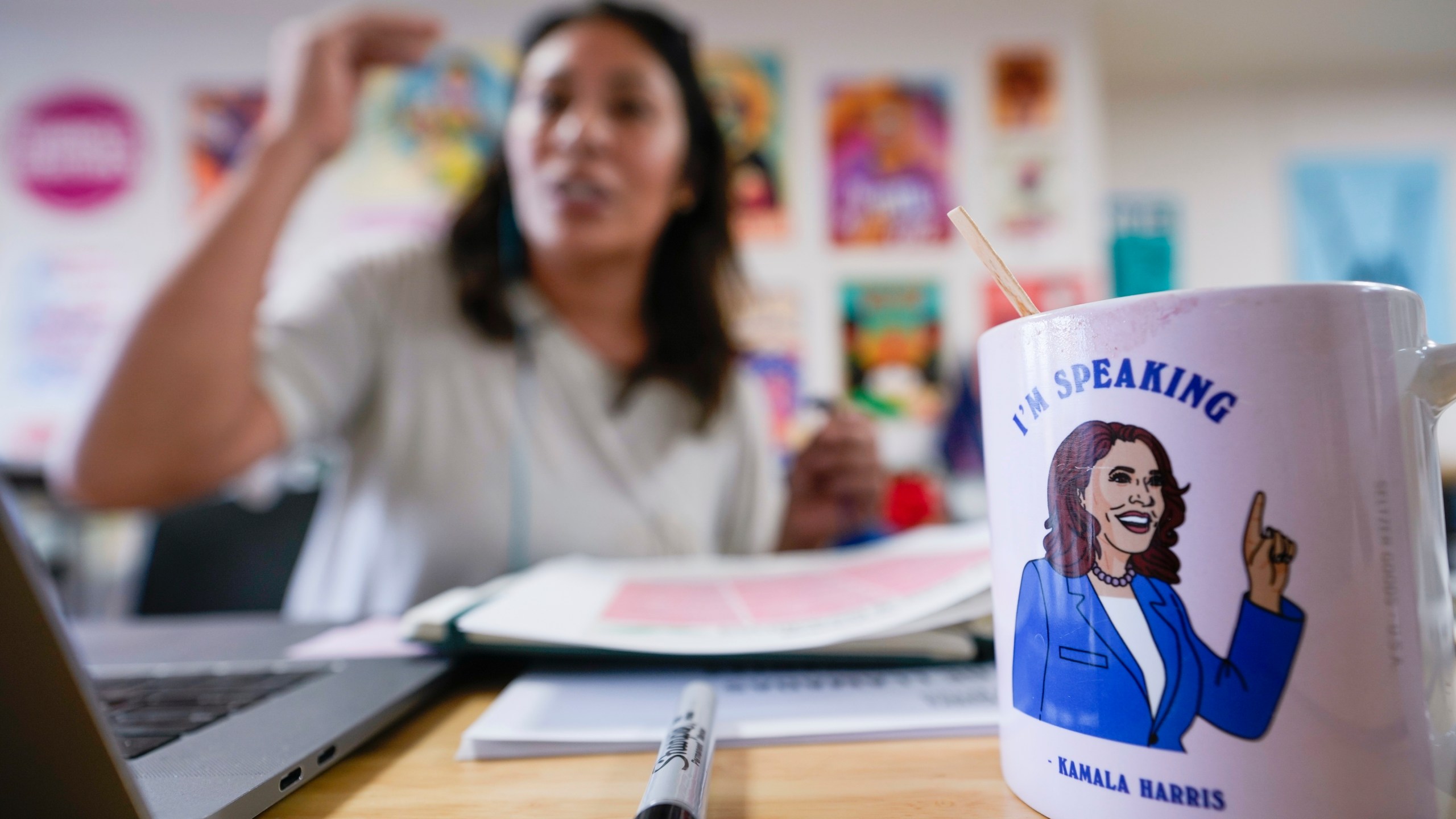 Emiliana Guereca, founder and president of the Women's March Foundation, speaks with potential voters from a phone bank near a mug with an image of Democratic presidential nominee Vice President Kamala Harris on Tuesday, Oct. 15, 2024, in Los Angeles. (AP Photo/Damian Dovarganes)