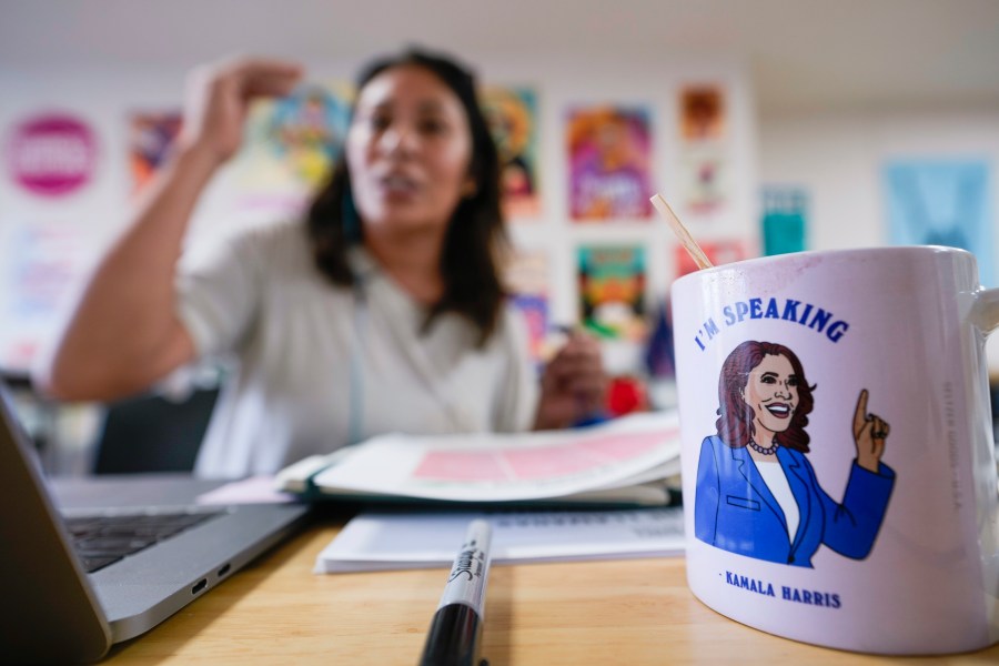 Emiliana Guereca, founder and president of the Women's March Foundation, speaks with potential voters from a phone bank near a mug with an image of Democratic presidential nominee Vice President Kamala Harris on Tuesday, Oct. 15, 2024, in Los Angeles. (AP Photo/Damian Dovarganes)