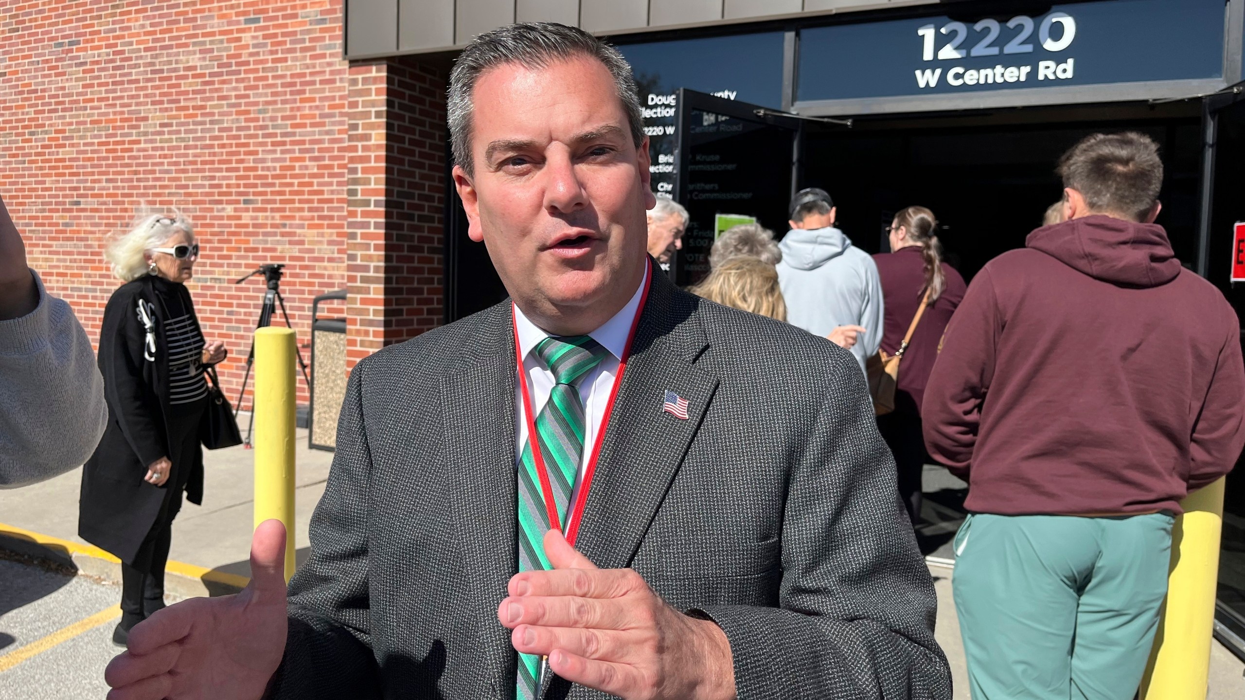 Douglas County Election Commissioner Brian Kruse stands outside the county's main election office as people line up to vote and register to vote in Omaha, Neb. on Wednesday, Oct. 16, 2024 . (AP Photo/Margery A. Beck)