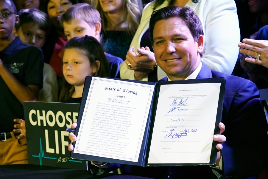 FILE - Florida Gov. Ron DeSantis holds up a 15-week abortion ban law after signing it on April 14, 2022, in Kissimmee, Fla. (AP Photo/John Raoux, File)