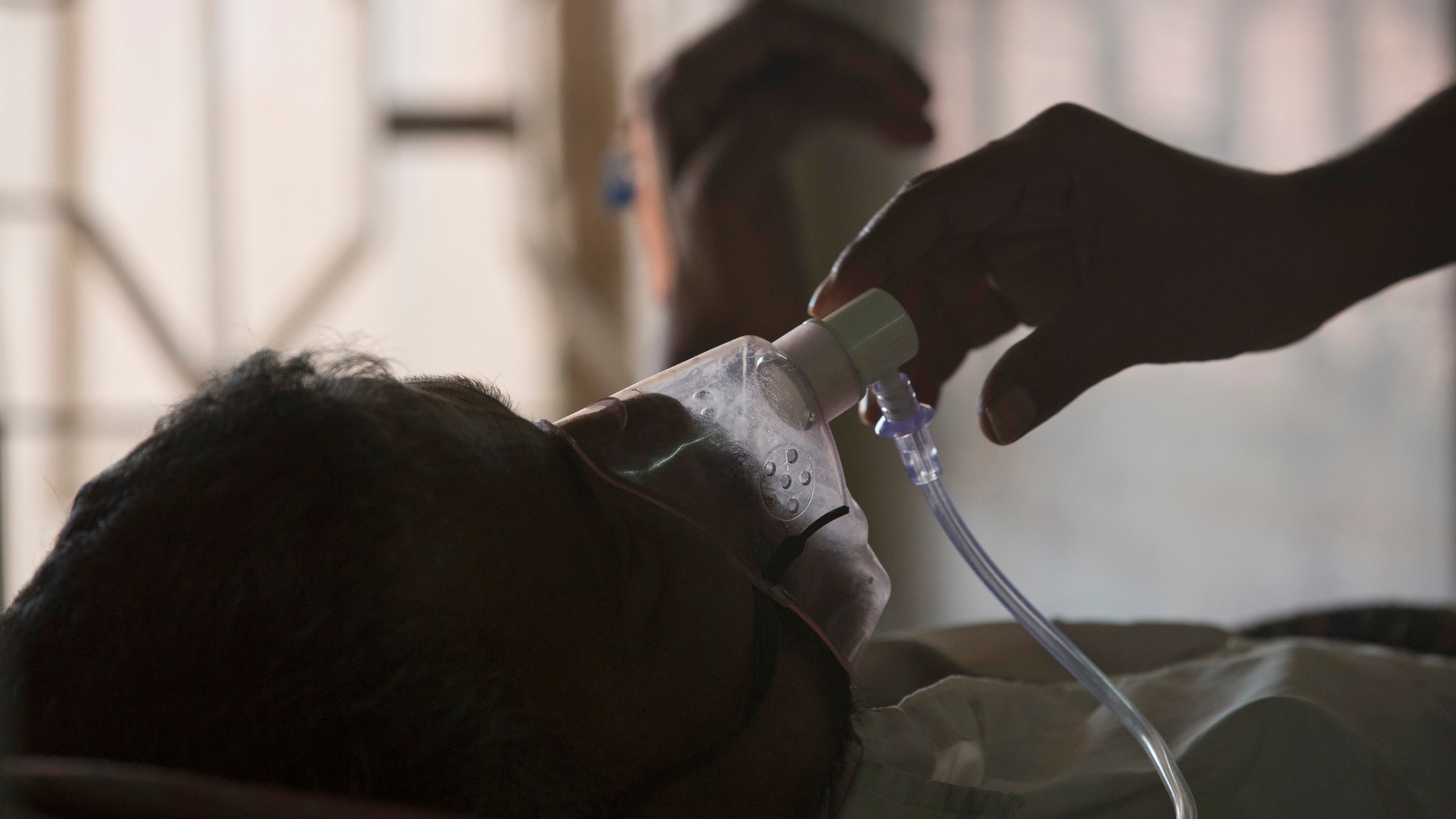 FILE - A relative adjusts the oxygen mask of a tuberculosis patient at a TB hospital on World Tuberculosis Day in Hyderabad, India, March 24, 2018. (AP Photo/Mahesh Kumar A., File)