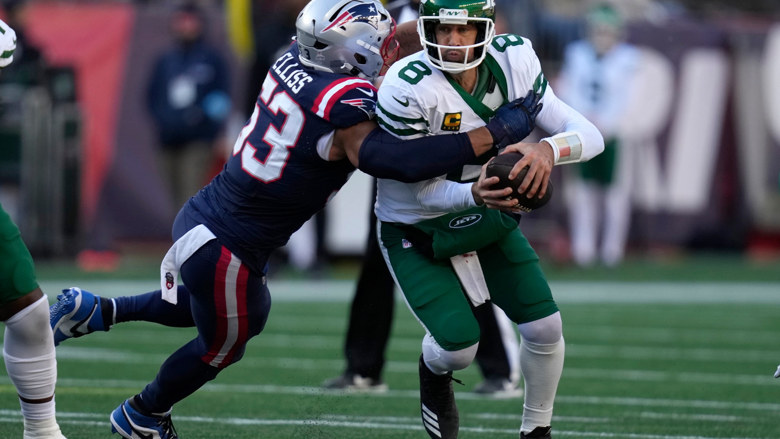 New York Jets quarterback Aaron Rodgers, right, is brought down by New England Patriots linebacker Christian Elliss, left, in the second half of an NFL football game, Sunday, Oct. 27, 2024, in Foxborough, Mass. (AP Photo/Charles Krupa)