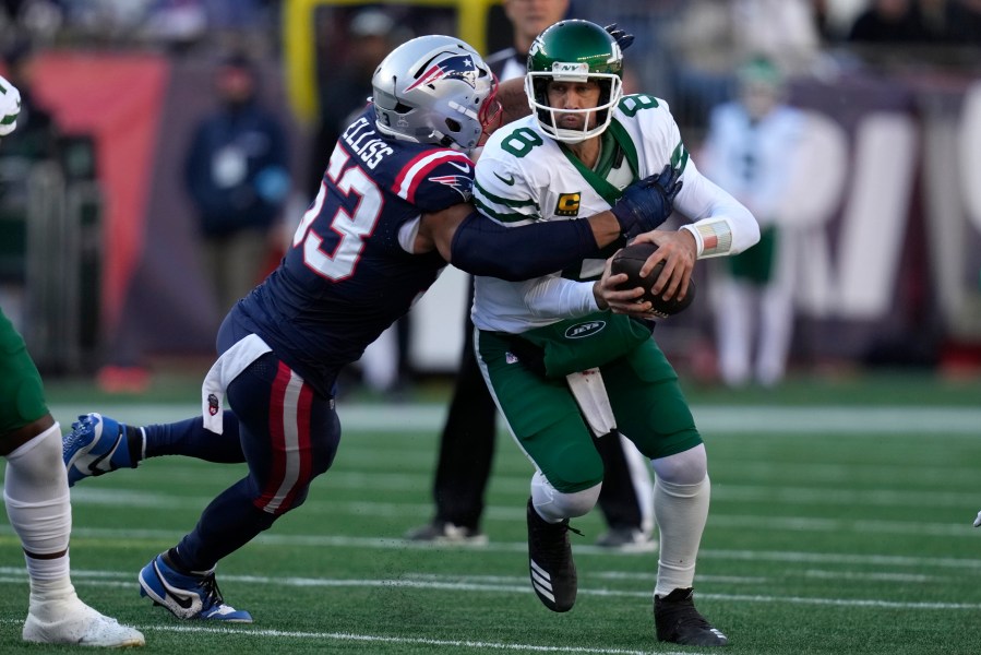 New York Jets quarterback Aaron Rodgers, right, is brought down by New England Patriots linebacker Christian Elliss, left, in the second half of an NFL football game, Sunday, Oct. 27, 2024, in Foxborough, Mass. (AP Photo/Charles Krupa)