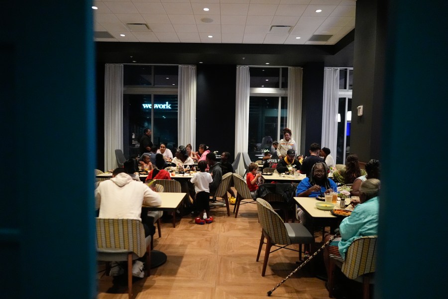 Off-duty staff members and their families, who were invited to come stay with them in hotel rooms as they worked through Hurricane Milton, eat dinner as the storm makes landfall on Florida's Gulf Coast, at Hyatt Place Tampa Downtown hotel in Tampa, Fla., Wednesday, Oct. 9, 2024.