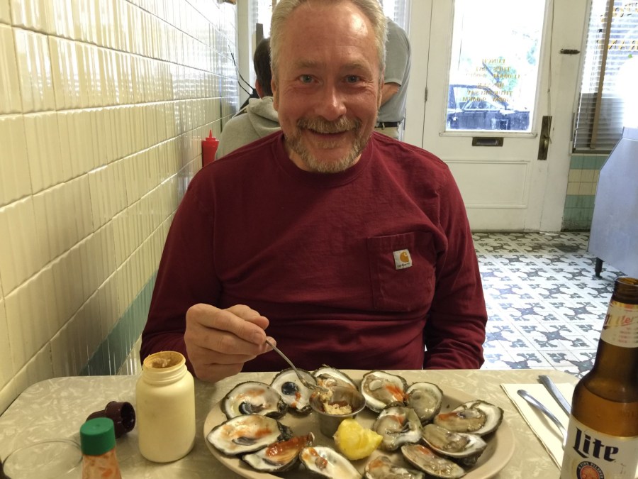 An older man eating oysters.