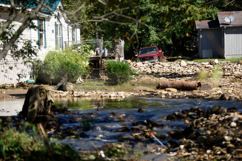 Jason Young clears debris and spreads loose dirt at his home off Flat Creek Road on October 2, 2024 in Black Mountain, North Carolina.