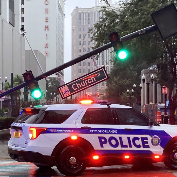 A police vehicle blocks an intersection where a traffic signal pole snapped in the downtown business area after Hurricane Milton passed through