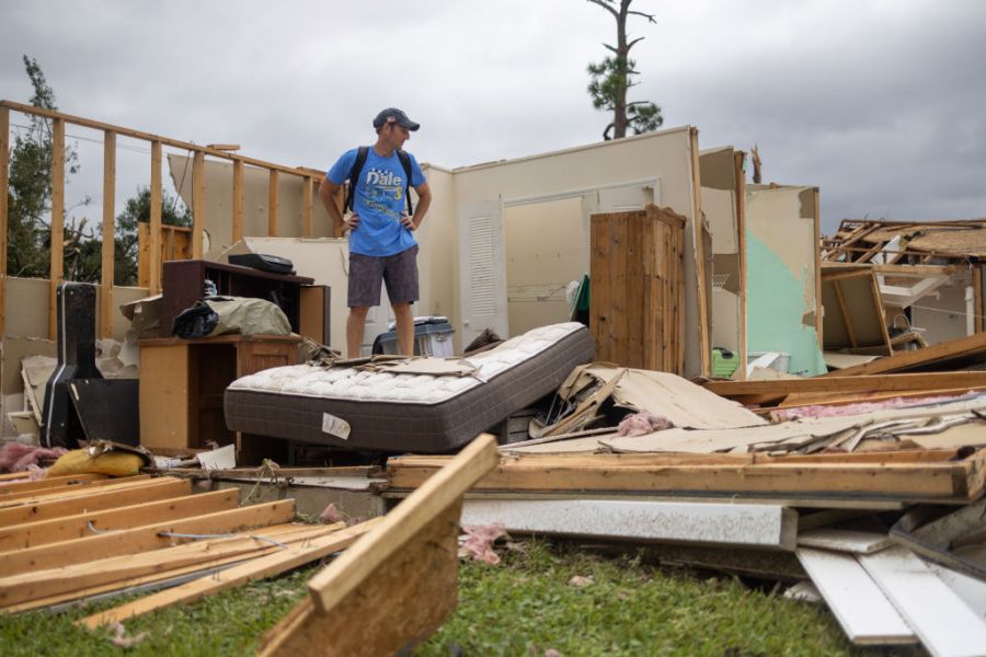 A Lakewood Park, Florida, resident stands among what's left of his home that was destroyed by a tornado spawned by Hurricane Milton.