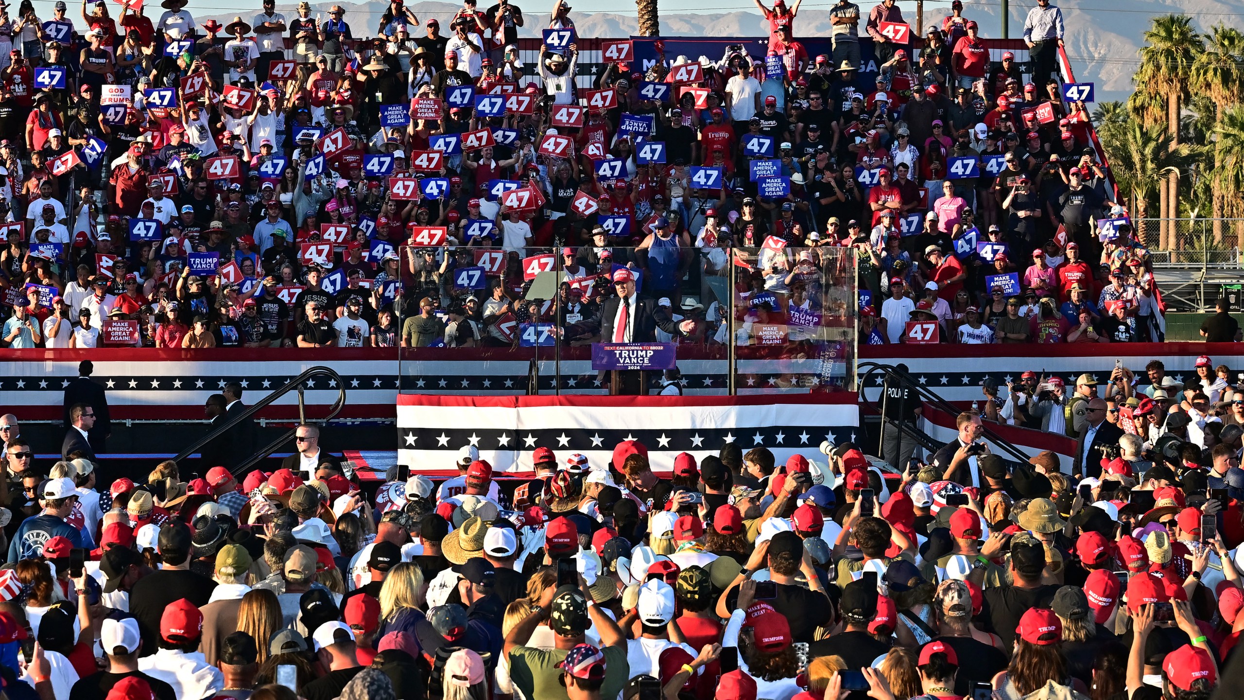 Former US President and Republican presidential candidate Donald Trump speaks during a campaign rally, surrounded by a crowd of people.