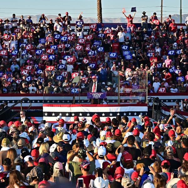 Former US President and Republican presidential candidate Donald Trump speaks during a campaign rally, surrounded by a crowd of people.