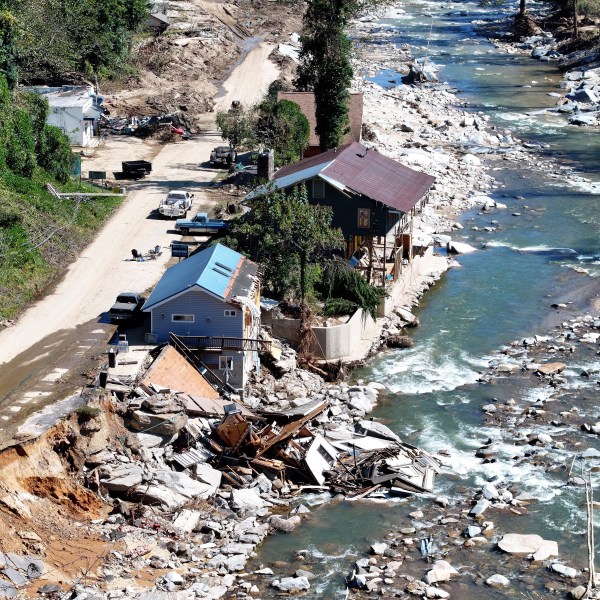 An aerial view of people standing near destroyed and damaged buildings in the aftermath of Hurricane Helene flooding on October 8, 2024 in Bat Cave, North Carolina.