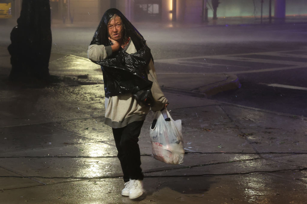 A woman walks through downtown Tampa, Florida, as Hurricane Milton makes landfall on Oct. 9, 2024.