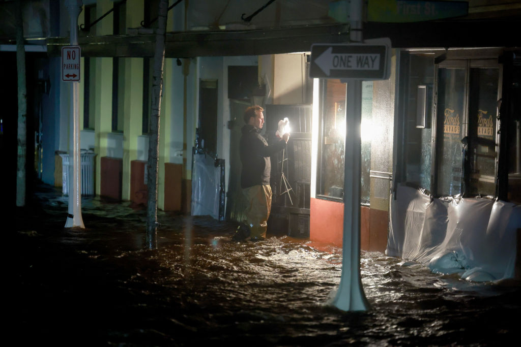 A person walks through surge waters after Hurricane Milton made landfall in the Sarasota area on October 09, 2024, in Fort Myers, Florida.