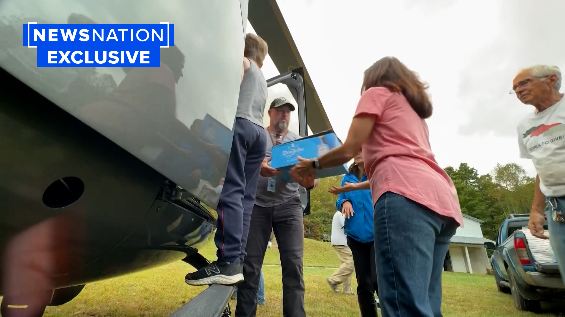 Men and women unload supplies from a helicopter