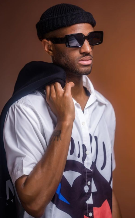 A  black man with sunglasses and a white shirt.