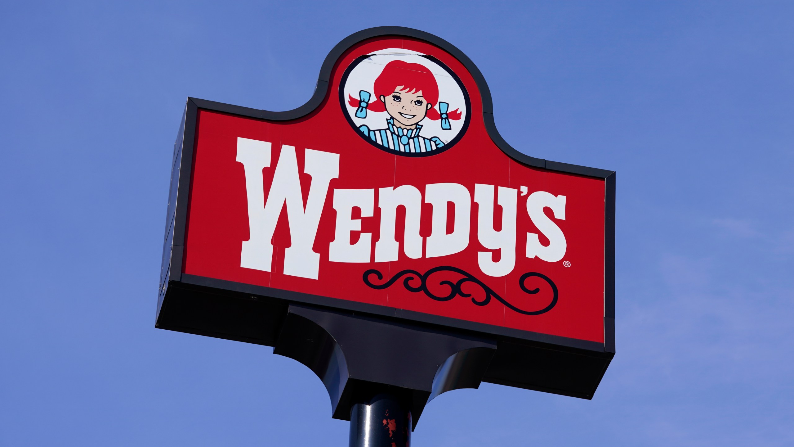 FILE - A sign for Wendy's restaurant stands over one of its locations, Feb. 25, 2021, in Des Moines, Iowa. (AP Photo/Charlie Neibergall, File)