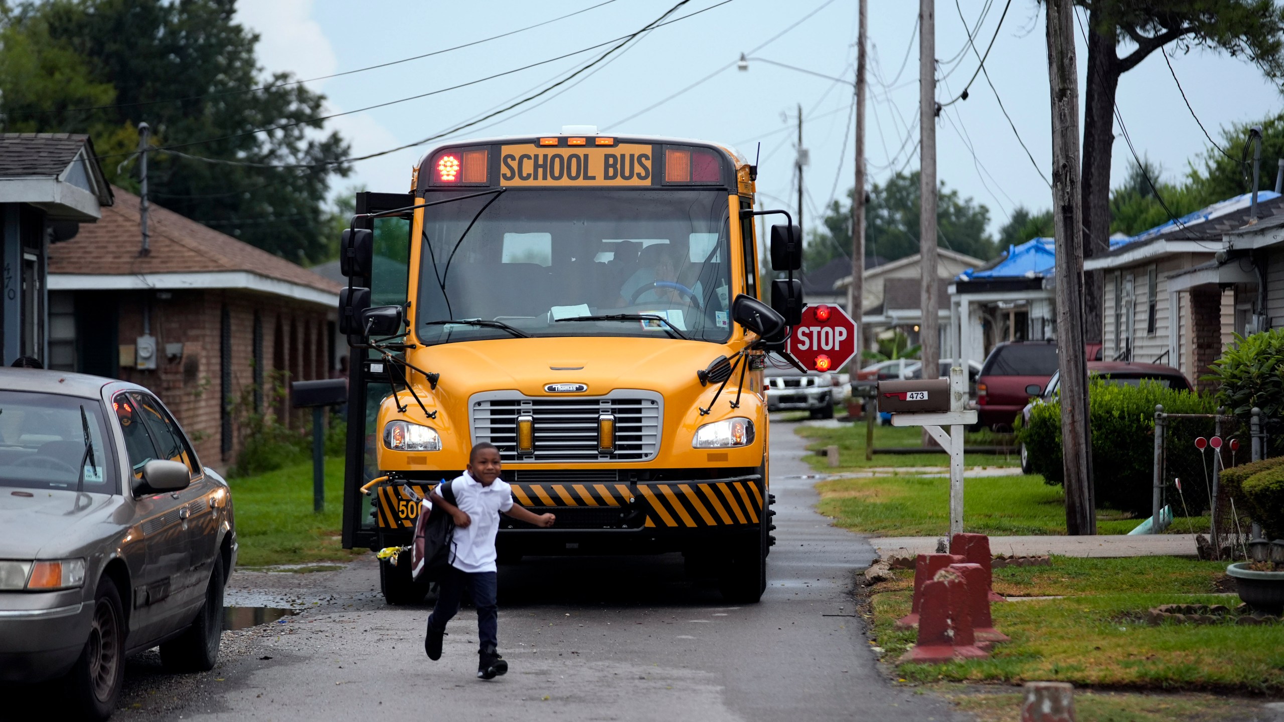 DeAnthony Nabor, 6, runs home from the school bus in the Elkinsville section of St. Rose, La., Friday, Aug. 16, 2024. (AP Photo/Gerald Herbert)