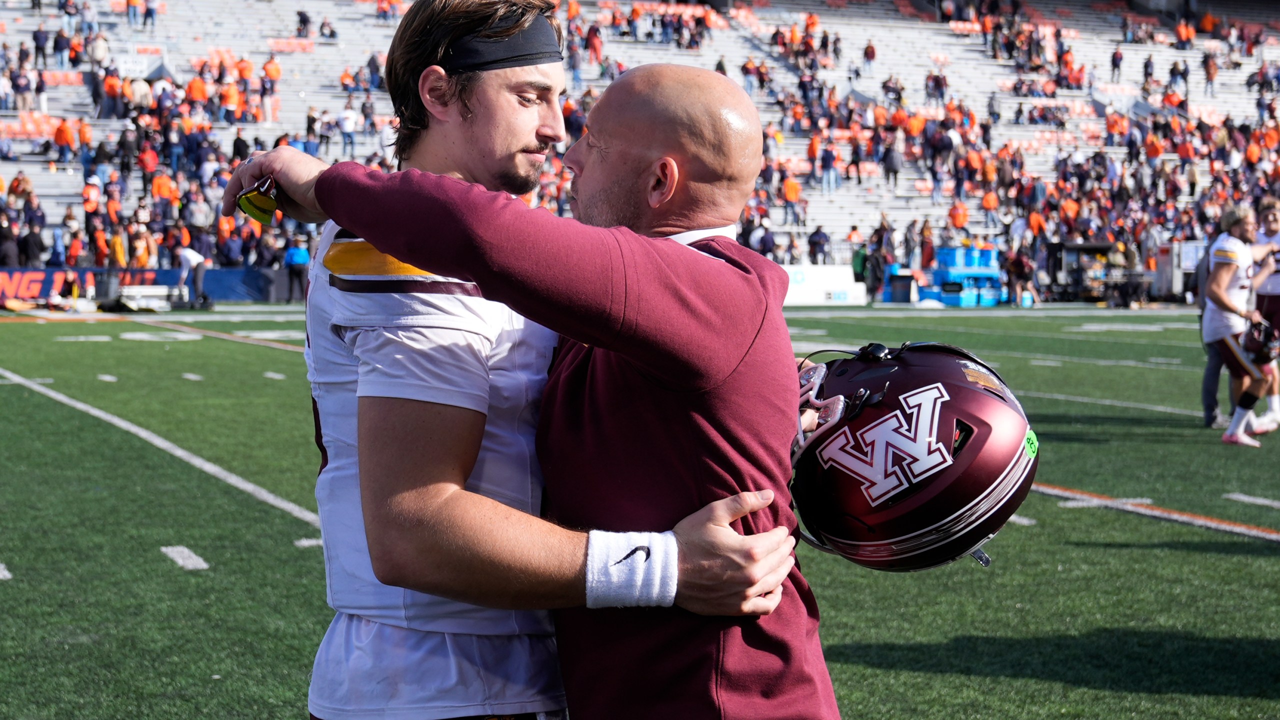 Minnesota head coach P.J. Fleck hugs quarterback Max Brosmer after the teams 25-17 win over Illinois in an NCAA college football game Saturday, Nov. 2, 2024, in Champaign, Ill. (AP Photo/Charles Rex Arbogast)