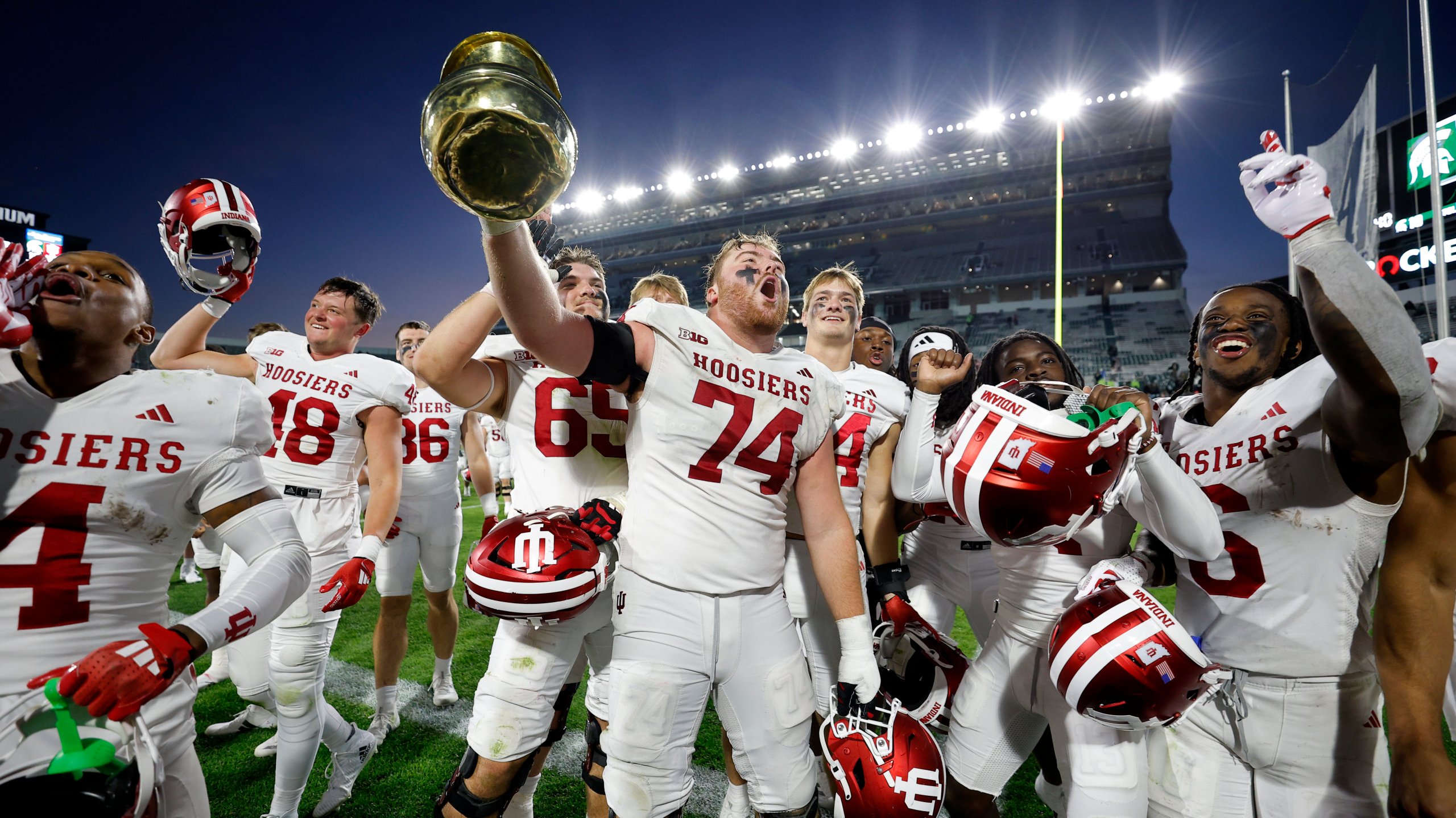 Indiana players, including offensive lineman Bray Lynch (74), celebrate with the Old Brass Spitoon after defeating Michigan State in an NCAA college football game, Saturday, Nov. 2, 2024, in East Lansing, Mich. (AP Photo/Al Goldis)