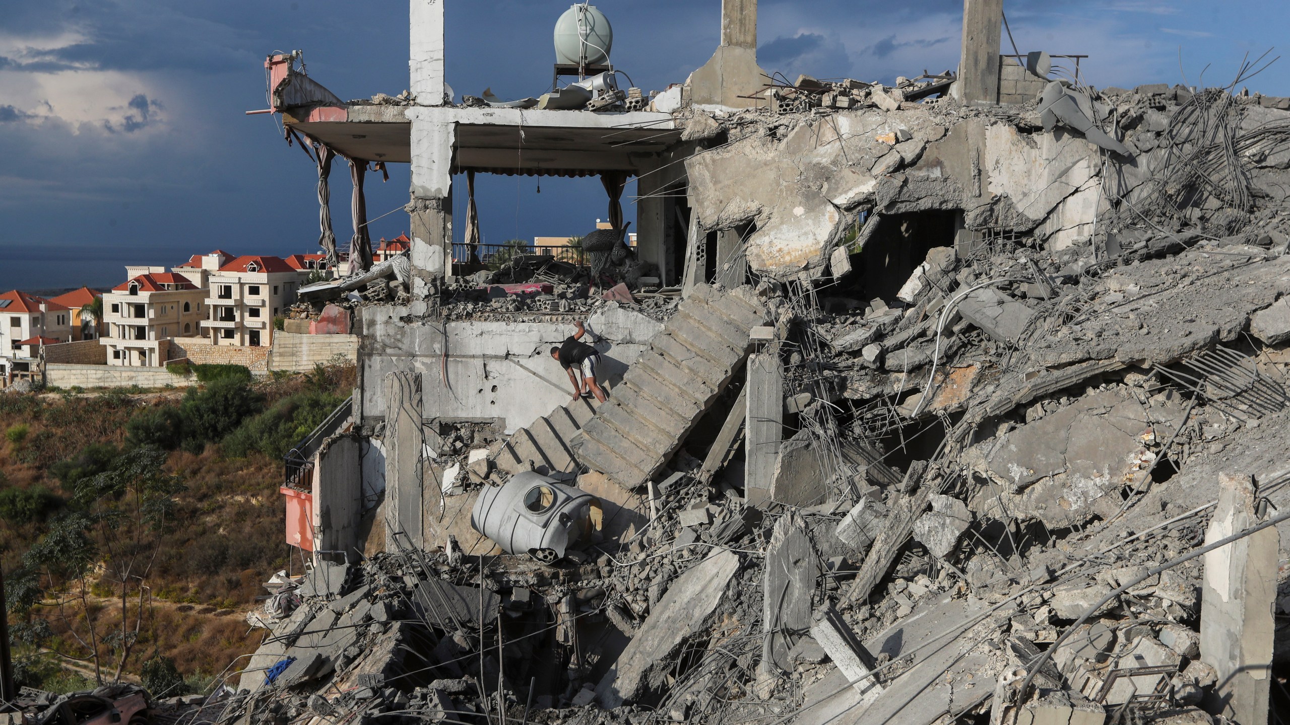 A man inspects a destroyed building hit in an Israeli airstrike, in Ghaziyeh town, south Lebanon, Sunday, Nov. 3, 2024. (AP Photo/Mohammed Zaatari)