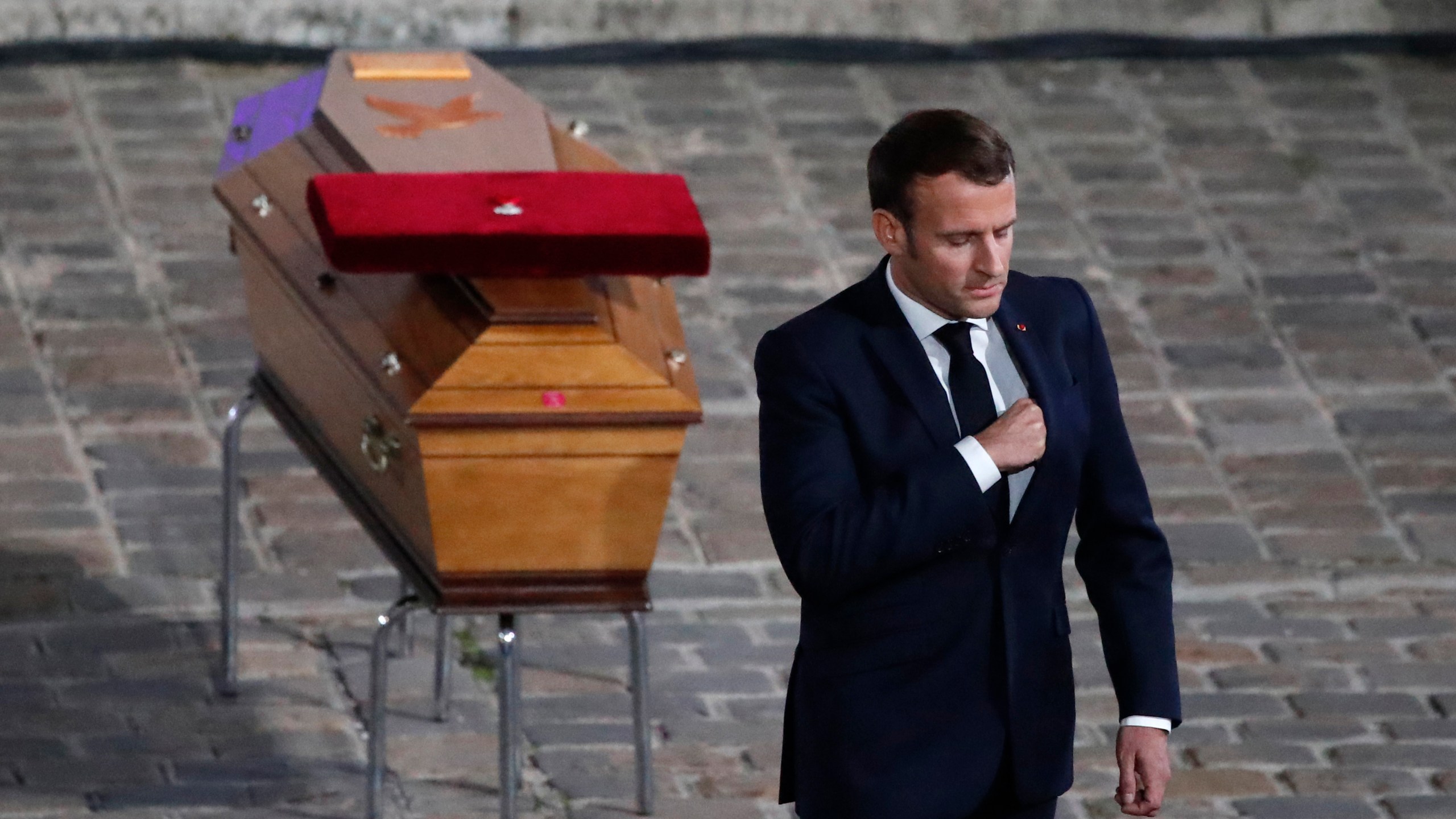 FILE - French President Emmanuel Macron leaves after paying his respects by the coffin of slain teacher Samuel Paty in the courtyard of the Sorbonne university during a national memorial event, Wednesday, Oct. 21, 2020 in Paris. (AP Photo/Francois Mori, Pool, File)