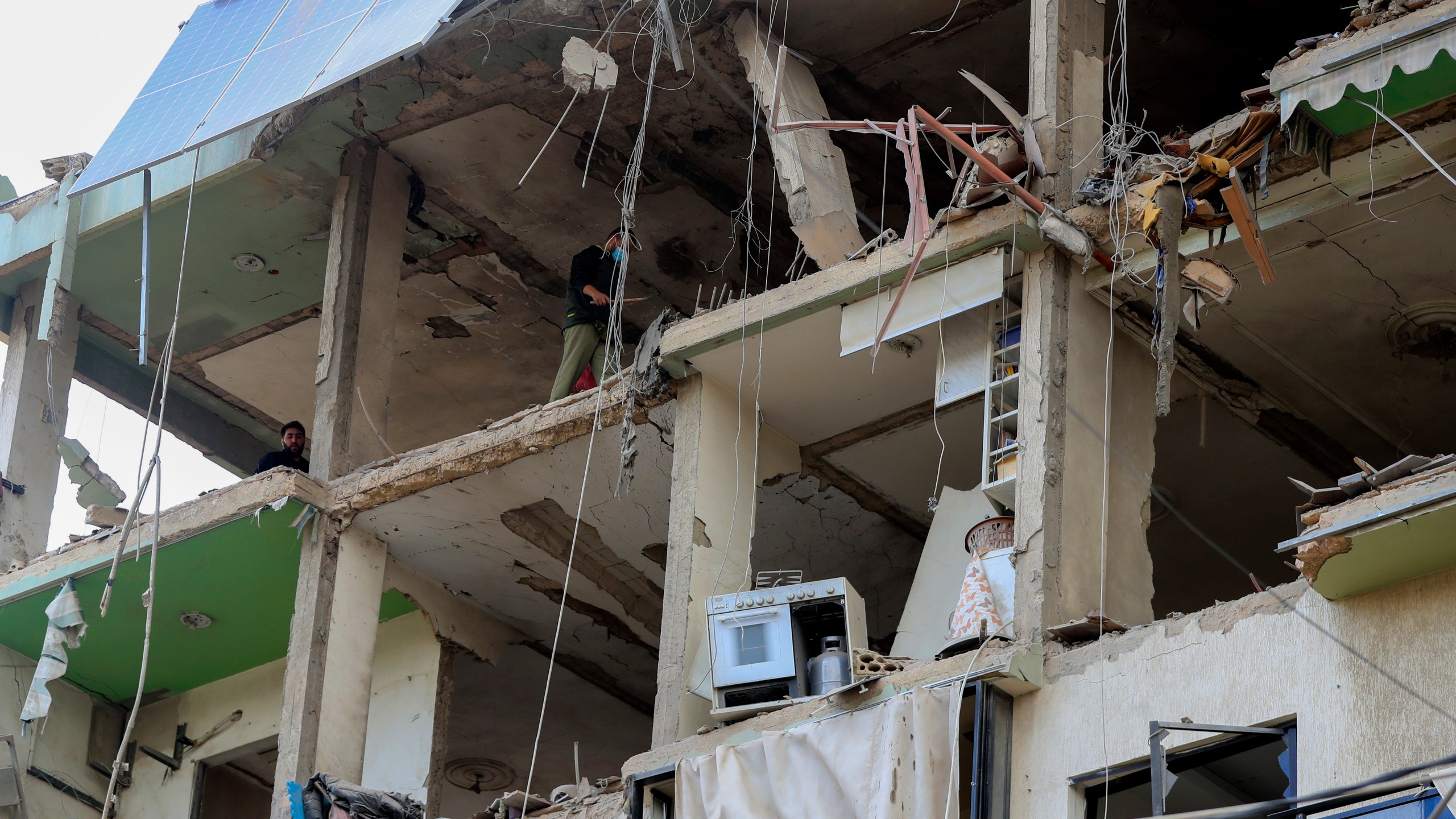 People inspect a destroyed building hit in an Israeli airstrike, in the southern port city of Sidon, Lebanon, Sunday, Nov. 3, 2024. (AP Photo/Mohammed Zaatari)