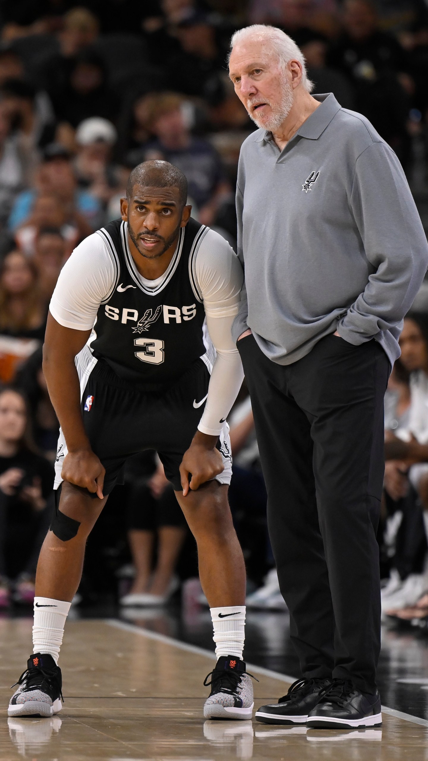 San Antonio Spurs head coach Gregg Popovich, right, speaks with Spurs guard Chris Paul, left, during the first half of an NBA basketball game against the Houston Rockets, Monday, Oct. 28, 2024, in San Antonio. (AP Photo/Darren Abate)