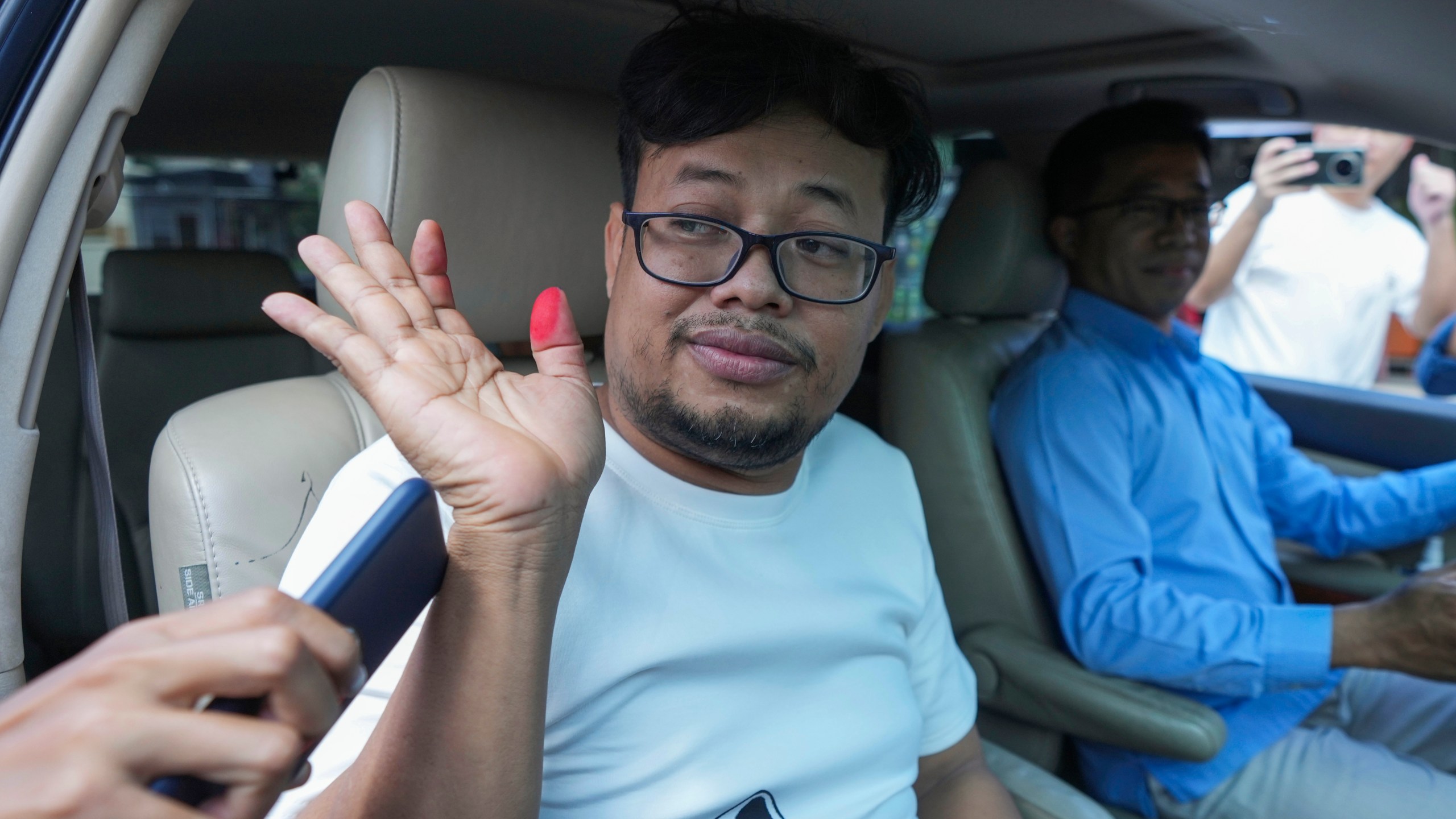 FILE - Cambodian freelance journalist Mech Dara, who was released on bail waves from a car in front of the main provincial prison of Kendal Province, southern Phnom Penh, Cambodia, on Oct. 24, 2024. (AP Photo/Heng Sinith)