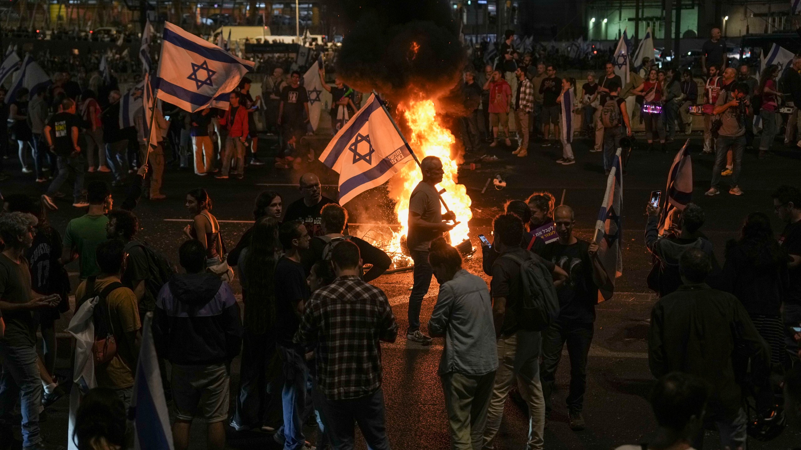 Israelis light a bonfire during a protest after Prime Minister Benjamin Netanyahu has dismissed his defense minister Yoav Gallant in a surprise announcement in Tel Aviv, Israel, Tuesday, Nov. 5, 2024. (AP Photo/Oded Balilty)