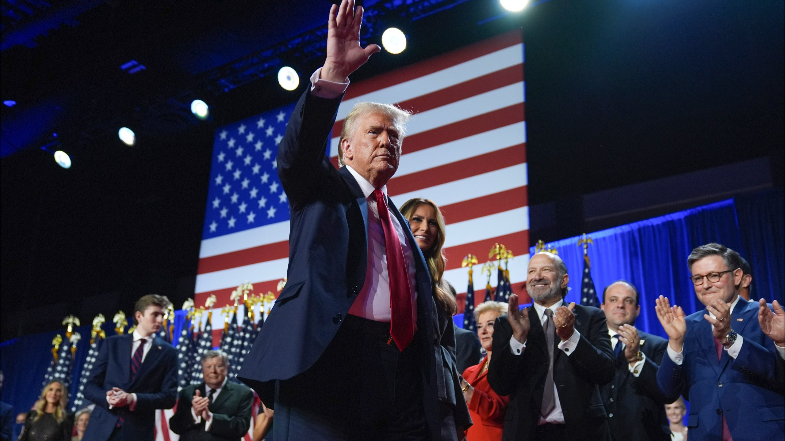 Republican presidential nominee former President Donald Trump waves as he walks with former first lady Melania Trump at an election night watch party at the Palm Beach Convention Center, Wednesday, Nov. 6, 2024, in West Palm Beach, Fla. (AP Photo/Evan Vucci)