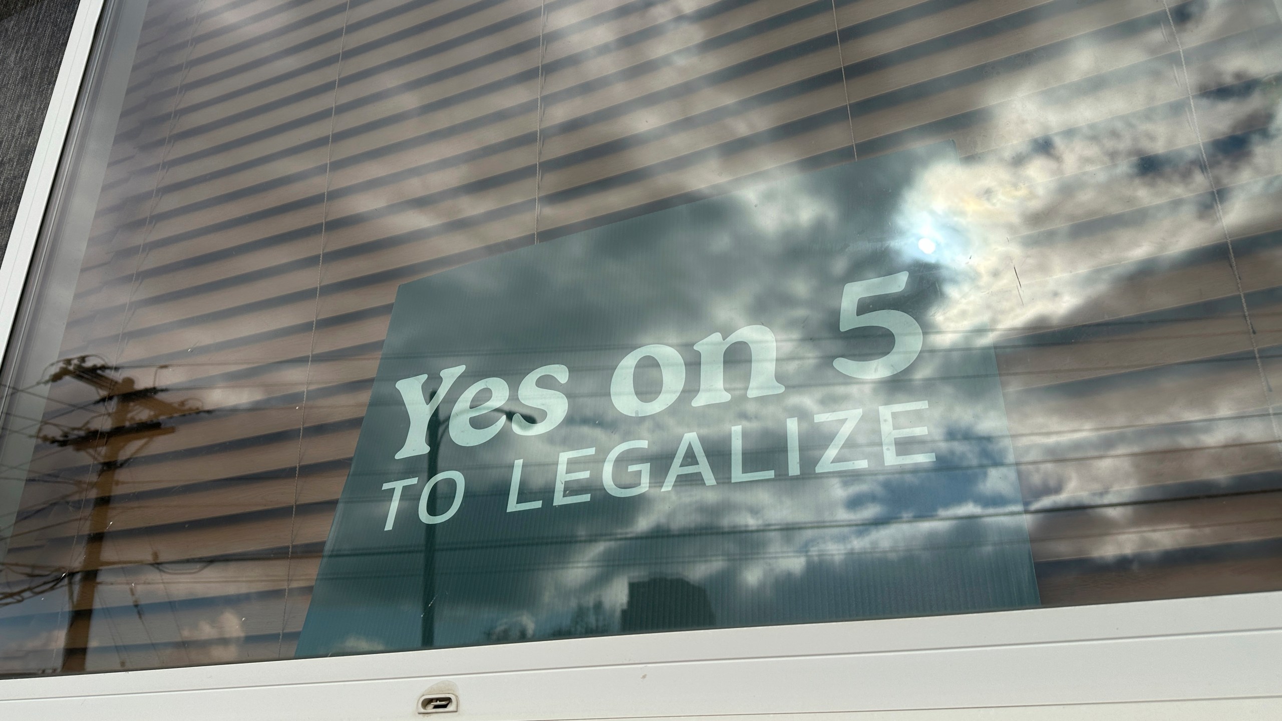 A sign in an apartment window in Bismarck, N.D., on Wednesday, Oct. 30, 2024, reads “Yes on 5 to legalize” in support of a ballot initiative that would legalize recreational marijuana in the state. (AP Photo/Jack Dura)