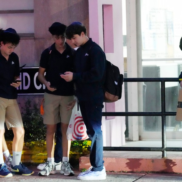 Students wait for their bus to school, Tuesday, Oct. 29, 2024, in Surfside, Fla. Daylight saving time ends at 2 a.m. local time Sunday, Nov. 3. Standard time will last until March 9. (AP Photo/Marta Lavandier)