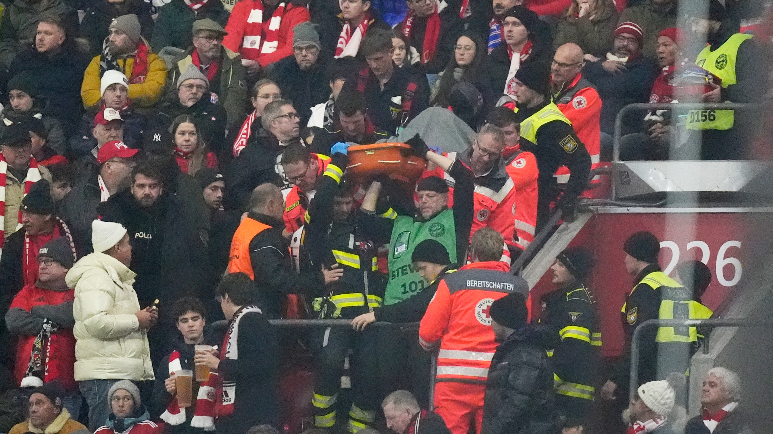 Police officers and paramedics carry a stretcher down the stands during a medical emergency during the Champions League opening phase soccer match between Bayern Munich and SL Benfica, in Munich, Germany, Wednesday, Nov. 6, 2024. (AP Photo/Matthias Schrader)