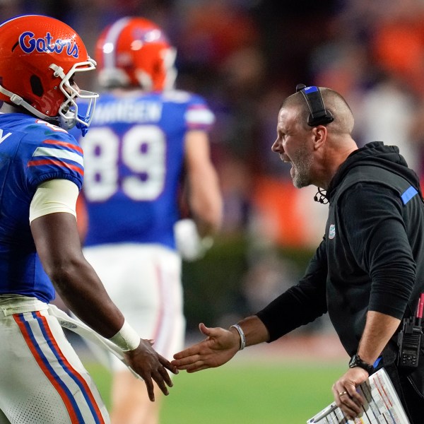 Florida head coach Billy Napier, right, greets quarterback DJ Lagway (2) as he comes off the field during the first half of an NCAA college football game against Kentucky, Saturday, Oct. 19, 2024, in Gainesville, Fla. (AP Photo/John Raoux)