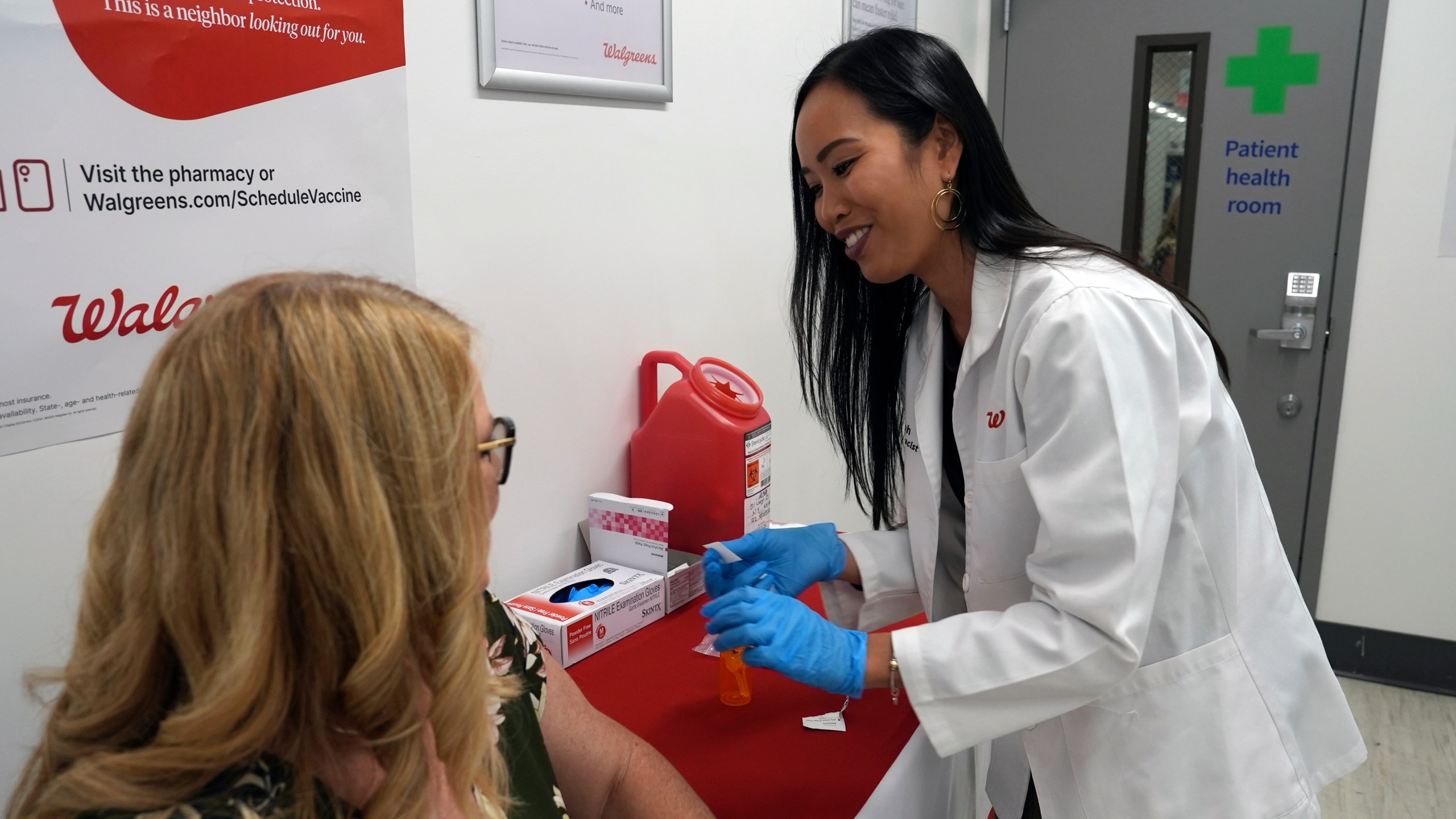 FILE - Anh Nguyen prepares to administer a COVID-19 vaccine for Kelly Vazquez at a pharmacy in New York, Sept. 24, 2024. (AP Photo/Mary Conlon, File)